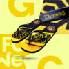 Ein Paar schwarz-gelbe Flip-Flops auf einem gelben Hintergrund. Auf den Sohlen ist in gelber Schrift „DRESDEN“ und in schwarzen Buchstaben „SGD“ zu lesen. Das Logo von Dynamo Dresden ist ebenfalls abgebildet. Im oberen rechten Bildausschnitt ist eine vergrößerte Ansicht des „Dynamo“-Schriftzugs zu sehen.