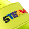 Ein Detailbild eines neongrünen Badeschuhs mit dem Schriftzug "STEAM", der aus einzelnen, mehrfarbigen 3D-Gummibuchstaben besteht.