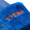 Ein Detailfoto einer blauen, flauschigen Haussandale mit dem orangefarbenen, gestickten Schriftzug "STEAM".