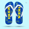 Ein einzelner blauer Flip-Flop mit weißen Riemen, der auf einem hellblauen Hintergrund schwebt. Die Sohle ist mit gelben Linien bedruckt, die verschiedene Möbelstücke zeigen. In der Mitte steht in großen, gelben Buchstaben „IKEA“.