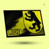 Eine Fußmatte, die auf einem gelben Hintergrund schwebt. Sie ist in den Farben Schwarz und Gelb gehalten und trägt das Wappen eines aufrecht stehenden Bären. Am linken unteren Rand steht in weißer Schrift „MICHA“.