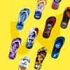 Eine Auswahl an verschiedenen Flip-Flops mit individuellen Designs schwebt vor einem gelben Hintergrund. Zu sehen sind unter anderem Motive von Star FM, Herbalife Nutrition und einem Sommerfest.