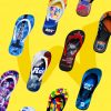 Eine Auswahl an verschiedenen Flip-Flops mit individuellen Designs schwebt vor einem gelben Hintergrund. Zu sehen sind unter anderem Motive von Star FM, Herbalife Nutrition und einem Sommerfest.