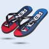 Ein Flip-Flop mit einer Sohle in den Farben Rot, Blau und Weiß. Darauf steht der Schriftzug "RENOVA" und "REN BY SERVICE".