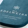 Eine Detailaufnahme eines Badeschuhs mit einer blau grauen Sohle und einem gedruckten Schriftzug auf der Ferse "DAS EDELWEISS".