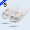 Un par de chanclas blancas de estilo "slide" flotando sobre un fondo azul claro. En la banda superior de cada chancla aparece un logotipo circular colorido. En la esquina superior izquierda se muestra un sello que dice "Print in Germany" con la bandera alemana y una etiqueta de "Express".