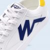 Primer plano del lateral de la zapatilla blanca que resalta la aplicación azul en forma de "W" y la calidad de las costuras dobles en el material.
