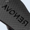 Macro de la suela de goma negra con textura de rombos y la palabra "RENOVA" grabada en negativo, diseñada para dejar huella en la arena.
