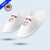 A pair of white hotel slippers shown at an angle, customized with the multicolored STEAM logo. Includes “Express” and “Print in Germany” stamps.
