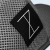High-resolution close-up of the breathable gray mesh fabric and the black label embroidered with a minimalist graphic symbol.